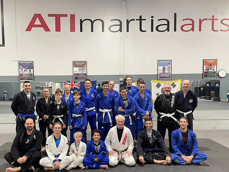 Group of martial artists wearing uniforms gathered inside the ATI Martial Arts Malaga HQ gym.