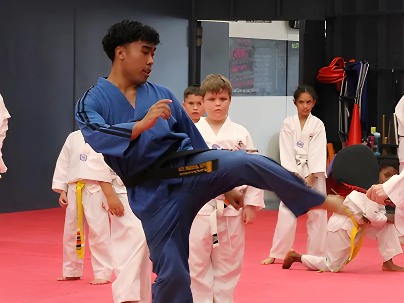 ATI Midland Instructor Anion demonstrating a kick for students during a class.