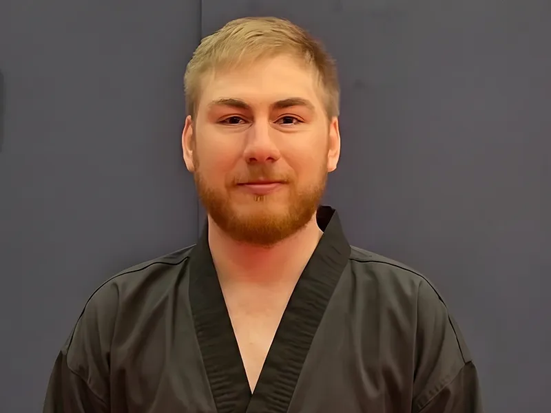 Headshot portrait of the ATI Martial Arts Midland head instructor in a black uniform.
